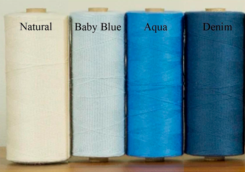 Four spools of thread labeled 'Natural', 'Baby Blue', 'Aqua', and 'Denim' on a wooden surface.